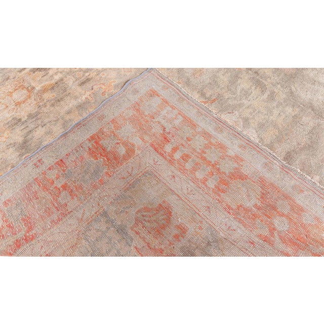 A striking example of early 20th-century Anatolian craftsmanship, this antique Turkish Oushak rug showcases the timeless...