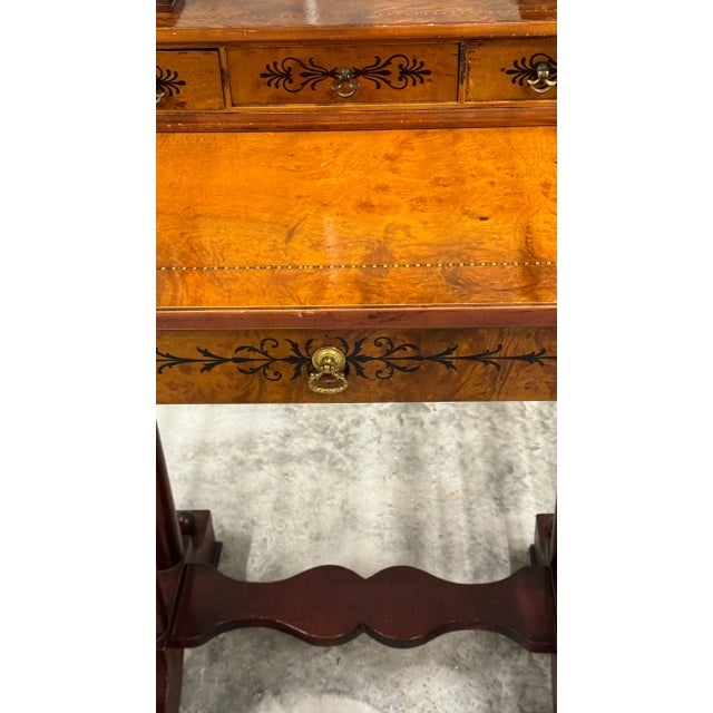 The table is a modified kidney shape in a beautiful Burl wood with inlay details. It has a tilt mirror with large BRASS...