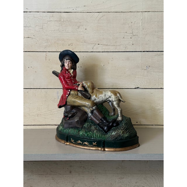 Hand painted cast iron doorstop depicting a colonial scene of seated hunting man and dog. Heavy and well made.
