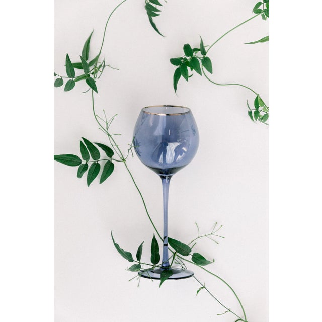 Set of 4 white wine goblets in Atlantic Blue with gold rim. Sleek stem, bulbous mouth, 16 oz. Ocean- inspired hues add...