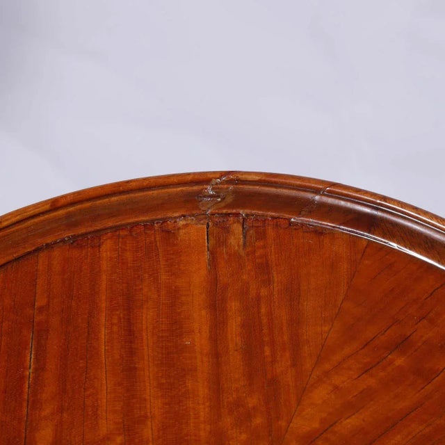 An antique pair of matching side stands offer mahogany construction with scolloped tops having satinwood crossbanding and...