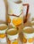 Charming vintage ceramic lemonade or juice set featuring a tall pitcher and five matching tumblers adorned with raised...