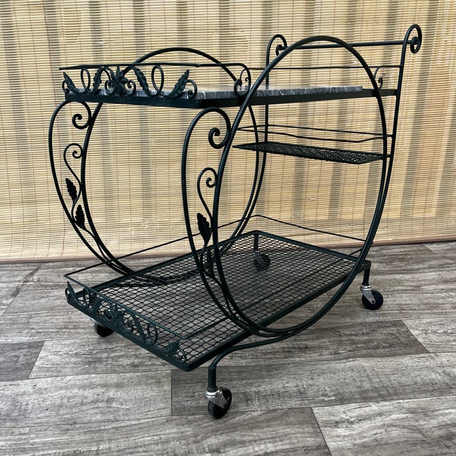 Vintage Mid Century Wrought Iron Marble Top Patio Serving Cart in the Salterini Style. Circa 1960s Features a wrought iron...