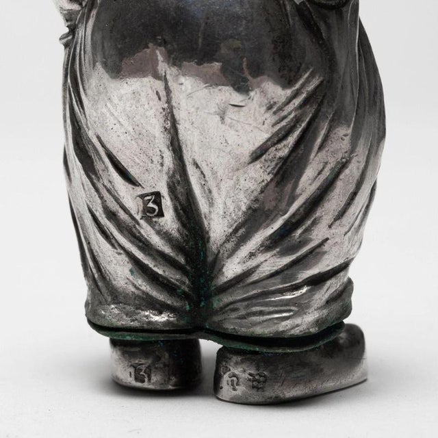 A Polish silver salt cellar in the shape of a figurine of a young porter, with hands tucked into pockets and a hat as a...