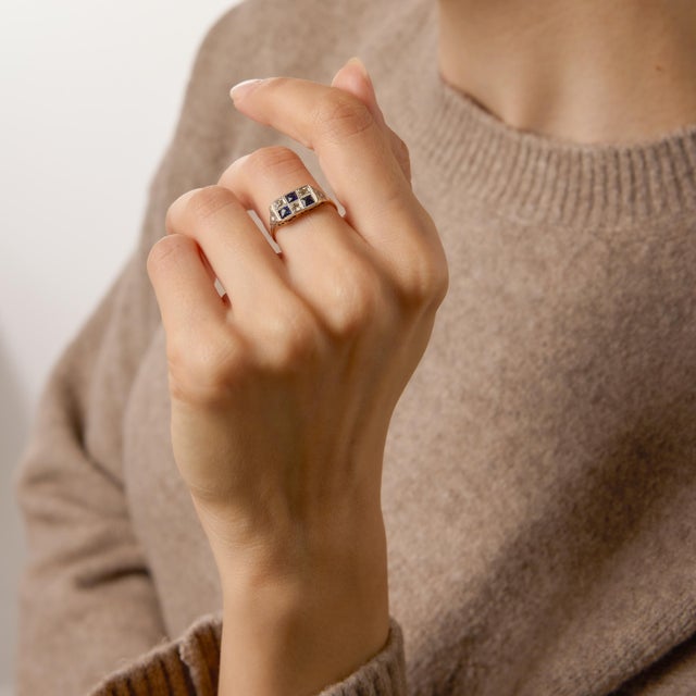A delicate jewel from the Edwardian era, this charming checkerboard ring showcases three square French cut synthetic...