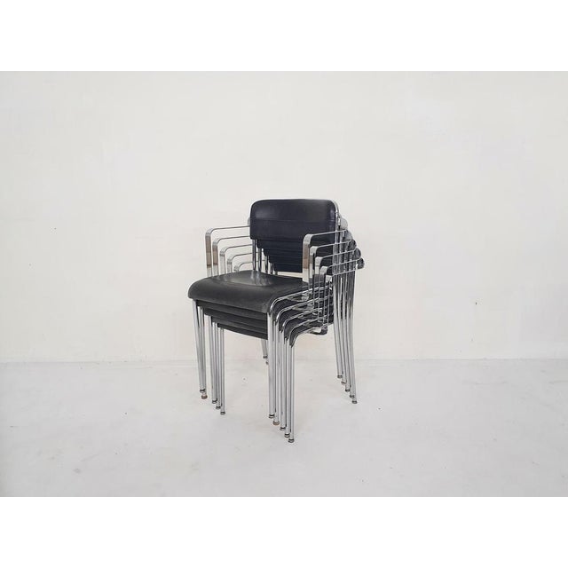 Stackable metal dining chairs with black leather upholstery. Manufactured by Aryform, Sweden. The design reminds us of the...