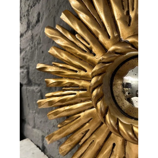 A hand carved gilt wood rope twist design sunburst mirror with a central convex distressed mirror with rope twist slip.