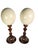 A pair of ostrich eggs mounted on antique wood basis with metal studs. Origin European, Circa 1900.