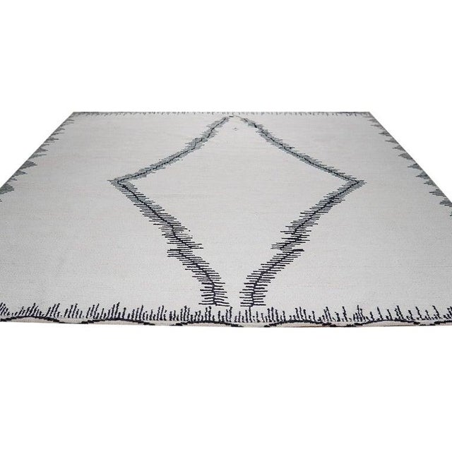 This hand knotted pile rug from Pakistan features a primary color palette of ivory, beige, cream, and white. Crafted from...