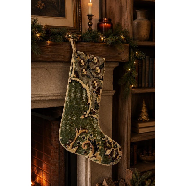 This vintage wool kilim stocking pairs a solid olive green lower body with a soft gray floral rosette pattern at the cuff,...