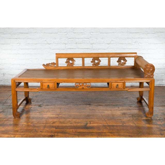 A Chinese Qing Dynasty period wooden lady's opium bed from the 19th century, with rattan seat, pillow, two small drawers...