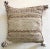 Woven cotton pillow in neutral tans with ivory and brown edged braids terminating in tassels at each corner. Backing in...