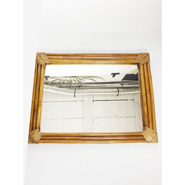 Decorative French rattan wall mirror dating from the 1990s. The rectangular mirror is surrounded by a structured frame...