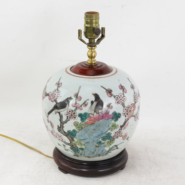 This antique table lamp is crafted from an authentic white porcelain vase featuring a classic Famille Rose garden scene....