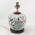 This antique table lamp is crafted from an authentic white porcelain vase featuring a classic Famille Rose garden scene....