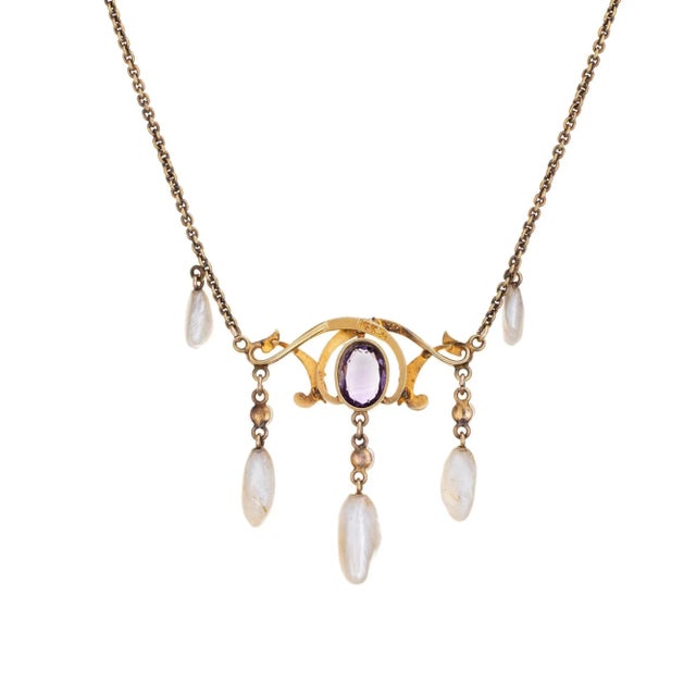 Stylish and finely detailed Art Nouveau drop necklace (circa 1900s to 1910s) crafted in 14 karat yellow gold. One...