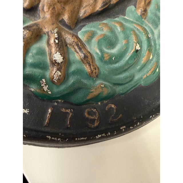 A striking vintage cast iron eagle wall plaque modeled after the historic emblem of the Insurance Company of North America...