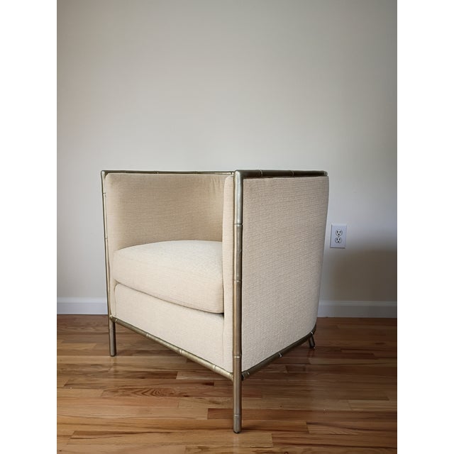 The Meredith Chair made by Bernhardt Interiors has a high back curved chair club chair that is trimmed in a metal faux...