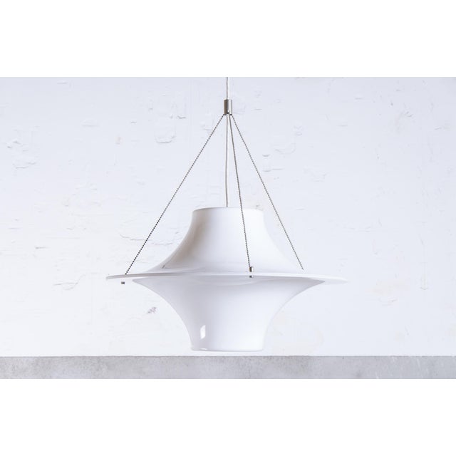 Skyflyer pendant lamp designed by Yki Nummi for Adelta. The lamp is comprised of a two-piece shade made of molded opaque...