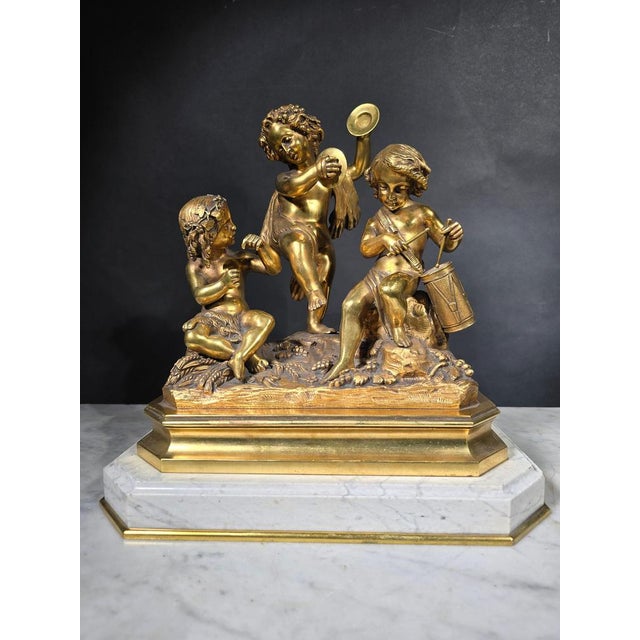 This elegant 19th-century gilded bronze sculptural group is a stunning piece of art. It is mounted on white Carrara...