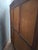 A solid mahogany Empire-style wardrobe with three doors, including a central glazed door fitted with its original wire...
