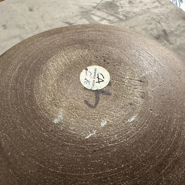 Refined centerpiece in porcelain stoneware, decorated in dark green and brown tones. Under the base, the manufacturer's...