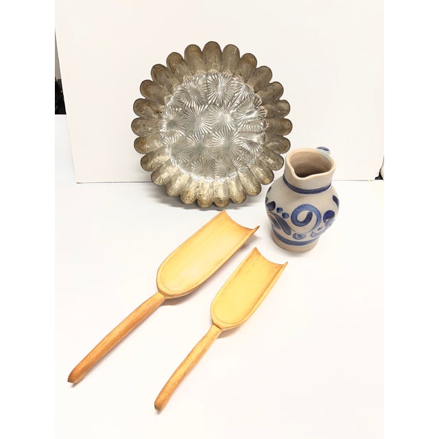 Great decorative set of four vintage kitchen items: a blue stoneware creamer, two hand carved wooden scoops, and a...