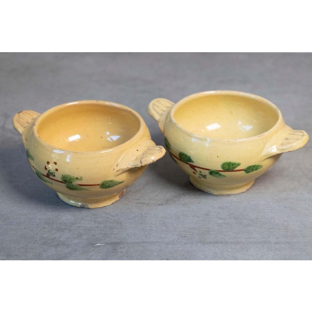 Two small 19th century French yellow glazed pottery drinking bowls from the town of Innimont, with stylized foliage...