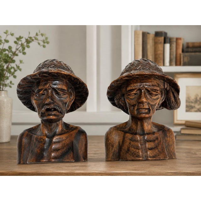 A wonderfully expressive matched pair of vintage hand-carved wooden busts from Bali, Indonesia, depicting an elderly rural...