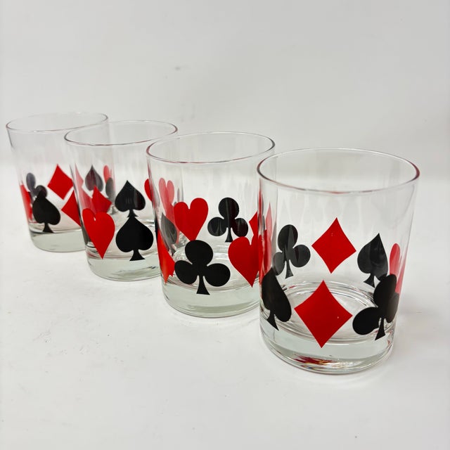 A vintage set of cocktail glasses with poker suit graphics, and a matching ice bucket.