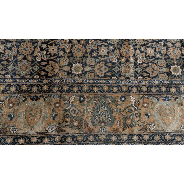 An early 20th century Kerman carpet from Southeast Persia, the midnight blue field with a herati pattern overall within a...