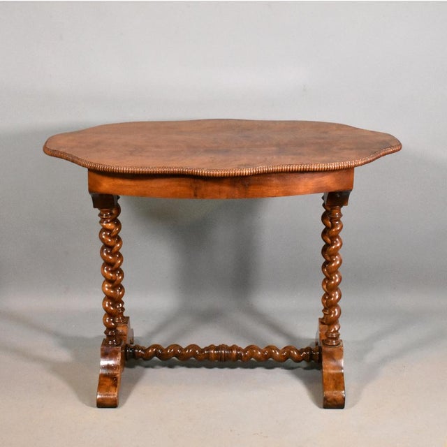 This Antique French Walnut Gueridon Centre Table features a striking book-matched wild grain walnut top with a shaped and...