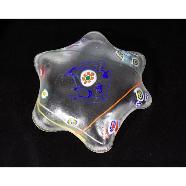 An art glass dish by American glass artist William Gottwalles. This flower-shaped dish has a ruffled edge and features...