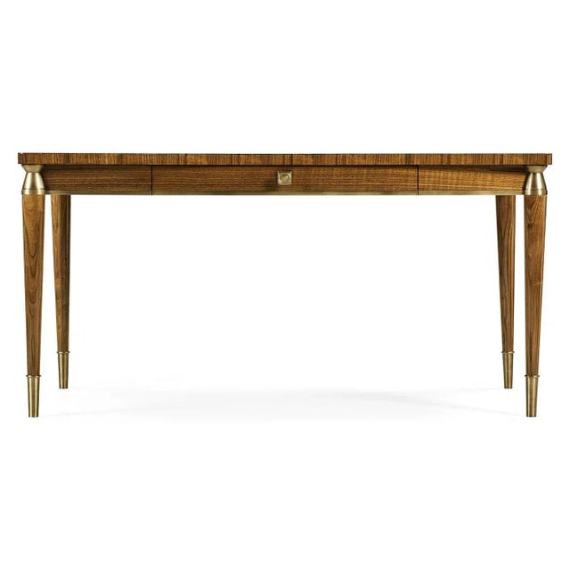 Mid Century modern style walnut desk with a quarter veneered writing surface, a long drawer, brass capital, and raised on...