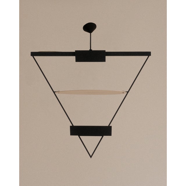 Suspension pendant by mario botta for artemide, italy, c. 1980. a suspended triangle of black metal and reflected light,...