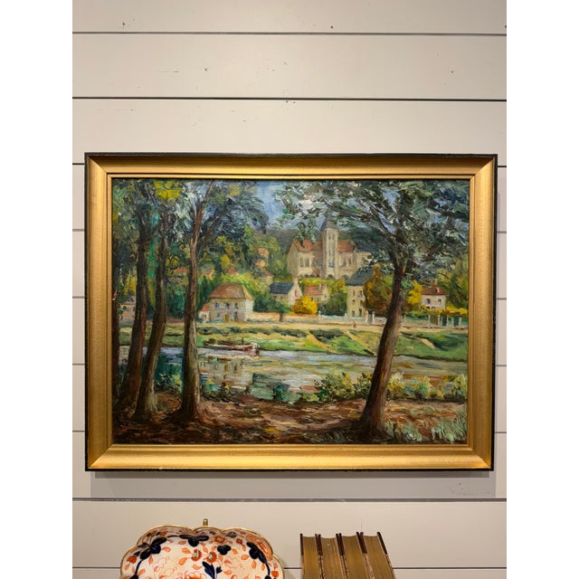 This is a lovely French oil on canvas depicting a lush, impressionist-style riverside landscape featuring trees flanking a...