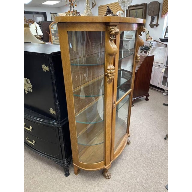 This is a beautiful antique hand carved curio cabinet made of tiger oak wood. The cabinet has three upper lights hardwired...