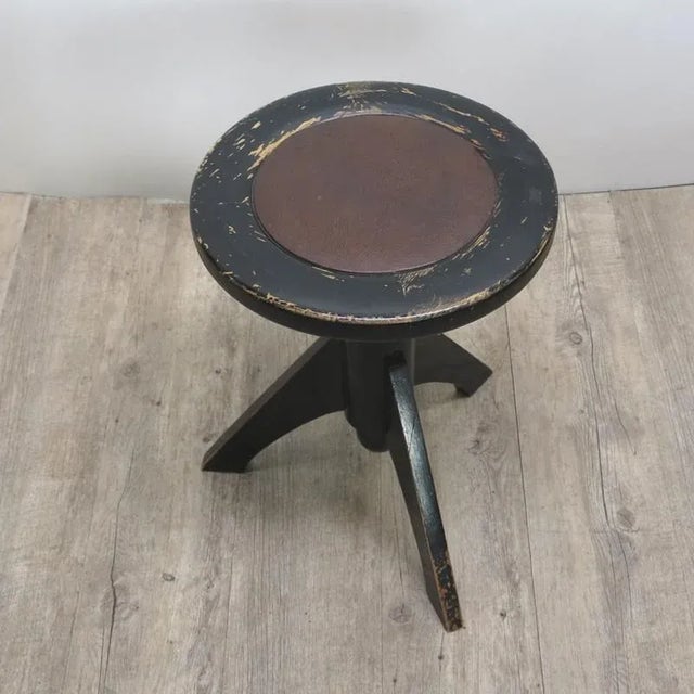 This rotating black wooden piano stool with a leather seat is height-adjustable from 45 to 60 cm.
