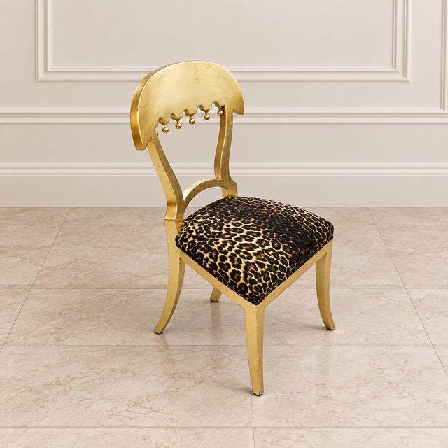 Make a bold statement with this distinctive French-style accent chair, featuring a sculptural gold leaf frame and...