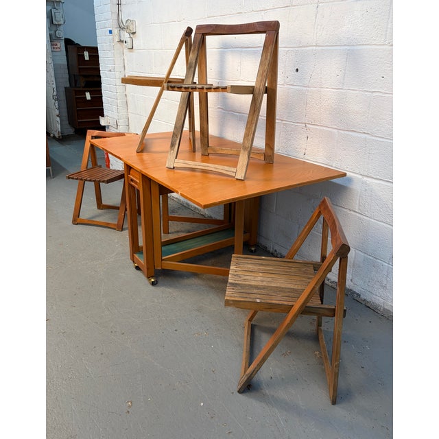 Add functional mid-century charm to your home with this Romanian Drop Leaf Hide-A-Way Table complete with four matching...