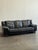 Black leather sofa made in Italy, showcasing the timeless elegance of mid-century modern design. Crafted around the 1980s,...