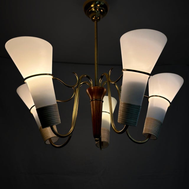 A large and impressive Swedish 1940s chandelier made from brass, featuring five curved arms holding cone-shaped shades in...