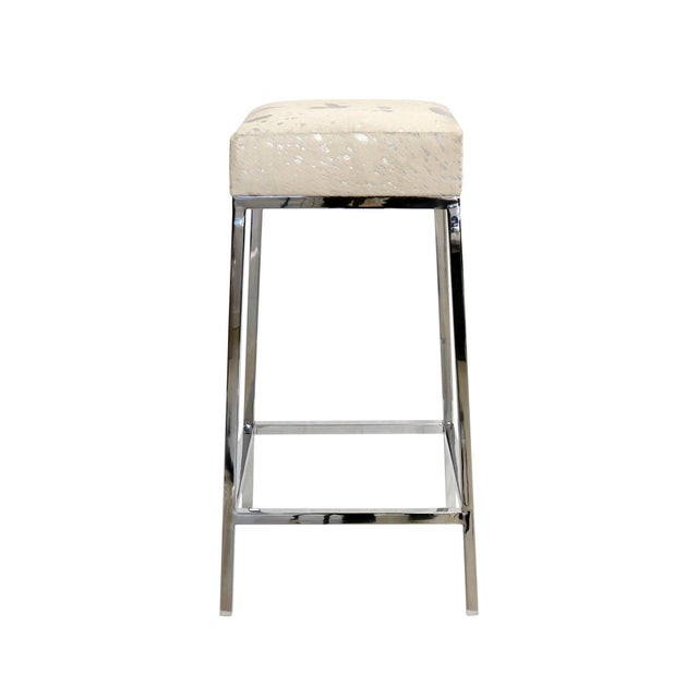 A striking fusion of natural texture and contemporary glamour, this bar stool is upholstered in supplecowhide accented...