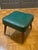 Add a touch of vintage charm to your space with this stylish mid-century modern footstool. Featuring a rich teal vinyl...