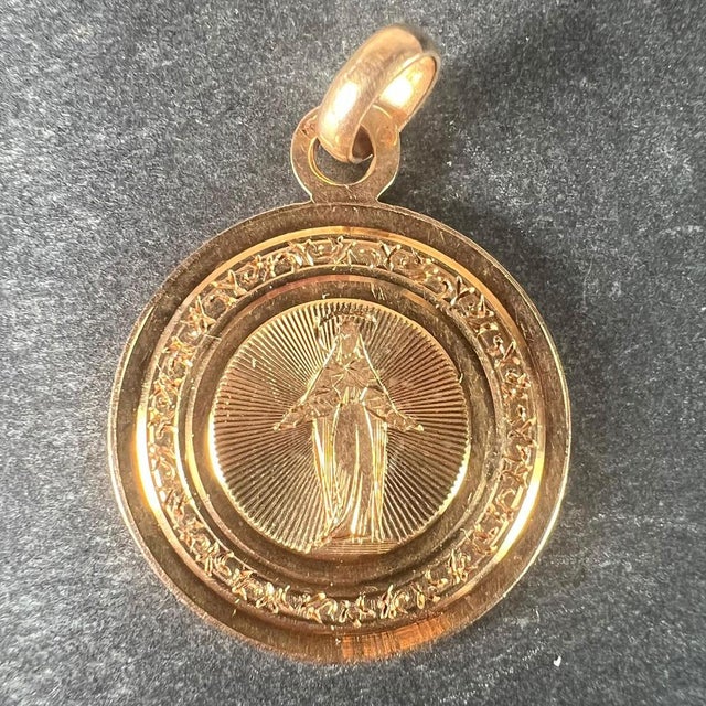 An antique French 18 karat (18K) rose gold charm pendant designed as a round medal depicting the Virgin Mary with...
