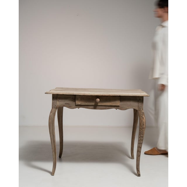 This 19th century Louis XV side table from France is finished in antique white, worked in oak. It is distinguished by its...