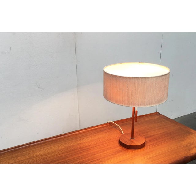 Mid-Century teak table lamp from the Swiss manufacturer Temde. Simple design language in high quality materiality. The...