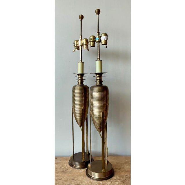 Illuminate your interiors with the architectural elegance of this pair of vintage brass table lamps by the esteemed...