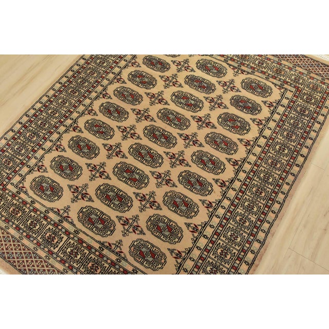 A tribal Bokhara rug hand-knotted with fine wool on a cotton foundation. This rug features rows of repeating medallions...