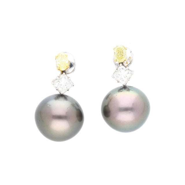 Natural 3.40 carat black pearl drop earrings set in 18K yellow and white gold with 0.94 carat fancy yellow and 1.49 carat...